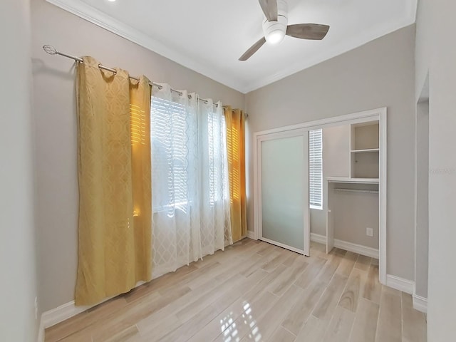 unfurnished bedroom featuring ceiling fan, ornamental molding, light hardwood / wood-style floors, and multiple windows