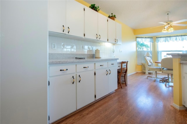 kitchen featuring tasteful backsplash, ceiling fan, light hardwood / wood-style floors, and white cabinets