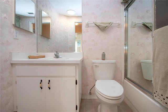 full bathroom with bath / shower combo with glass door, vanity, tile patterned floors, and toilet