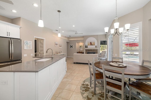 kitchen featuring white cabinetry, a fireplace, sink, and pendant lighting