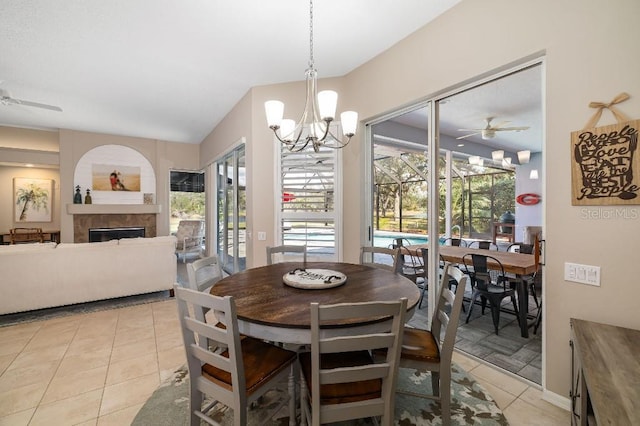 tiled dining area featuring a tiled fireplace and ceiling fan