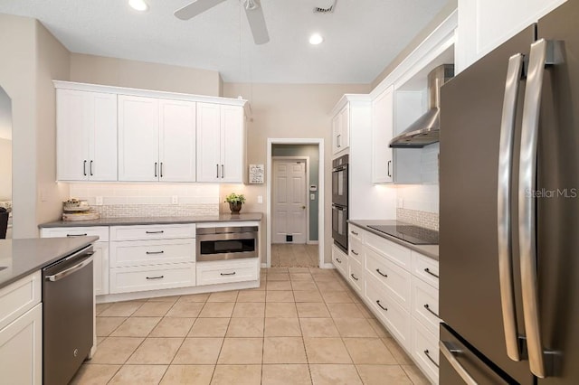 kitchen with backsplash, white cabinets, wall chimney range hood, and black appliances