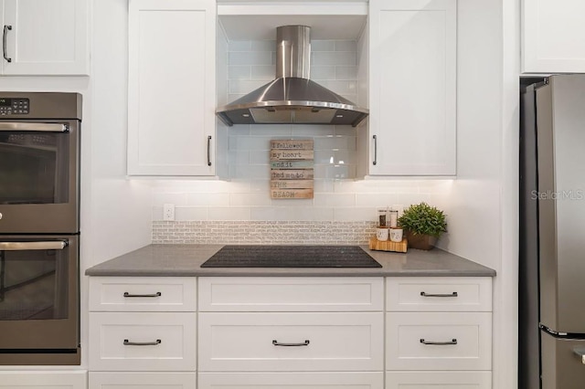 kitchen featuring stainless steel appliances, decorative backsplash, white cabinets, and wall chimney exhaust hood