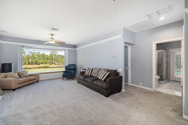 living room with ceiling fan, light carpet, and a textured ceiling