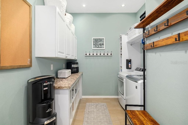 washroom with cabinets and washing machine and dryer