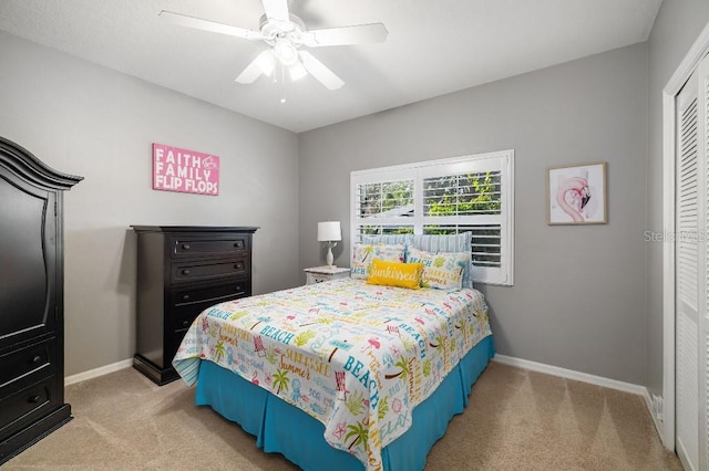 bedroom featuring ceiling fan, a closet, and light carpet