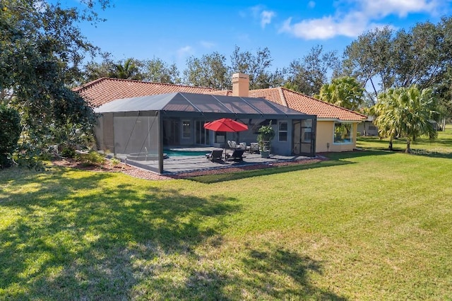 rear view of property with a patio, glass enclosure, and a lawn