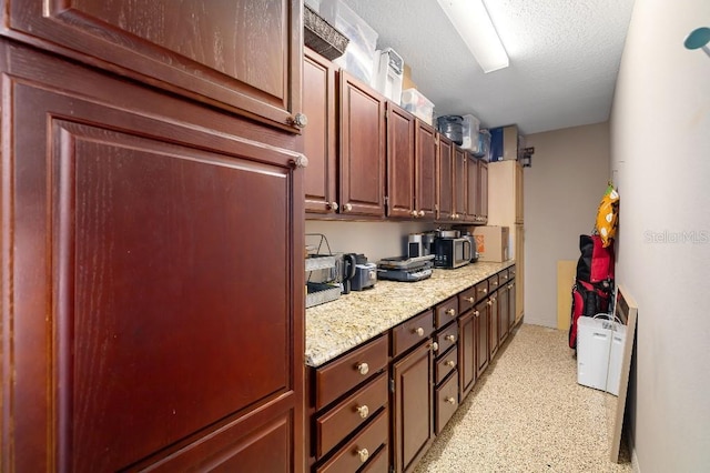 kitchen featuring light stone countertops and a textured ceiling