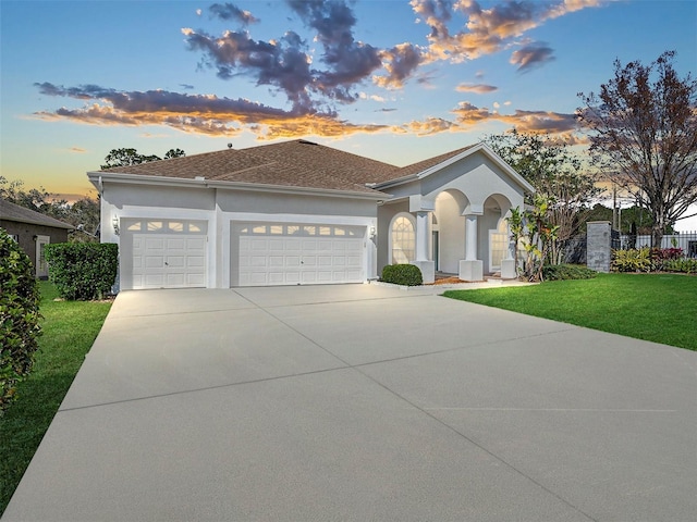 mediterranean / spanish-style home featuring a garage and a yard