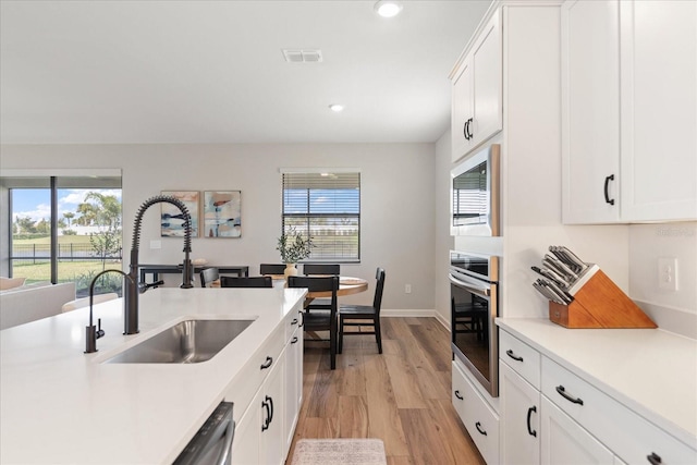 kitchen with white cabinetry, sink, a healthy amount of sunlight, and appliances with stainless steel finishes