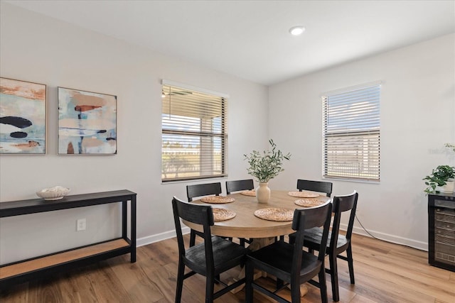 dining space featuring wine cooler, plenty of natural light, and light hardwood / wood-style floors