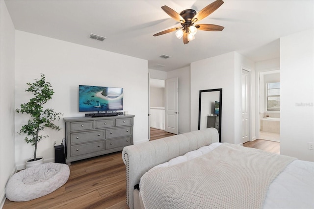 bedroom with connected bathroom, dark hardwood / wood-style floors, and ceiling fan