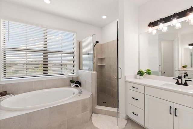 bathroom with vanity, separate shower and tub, and a wealth of natural light