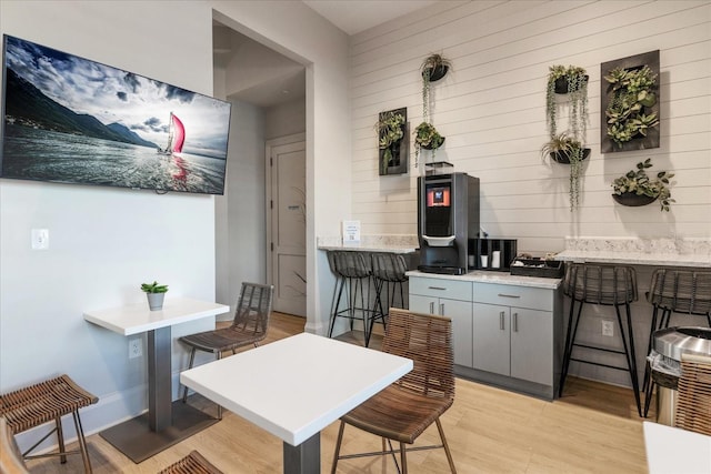 kitchen featuring a kitchen bar, light wood-type flooring, and gray cabinetry