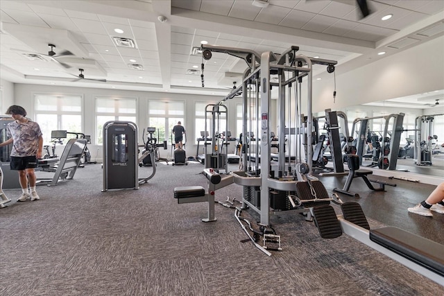 workout area with a paneled ceiling and ceiling fan