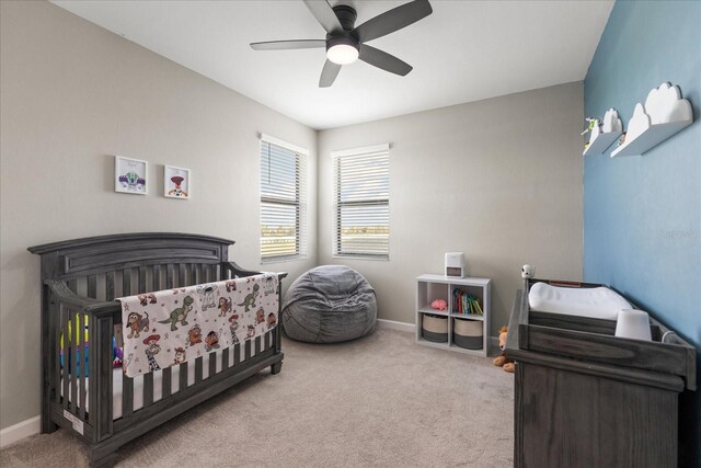 carpeted bedroom featuring baseboards and a ceiling fan