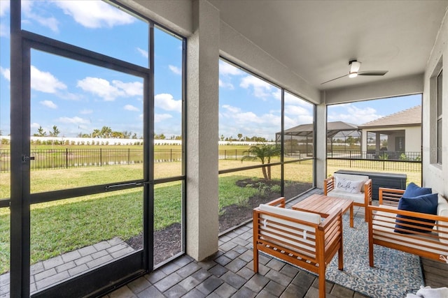 sunroom featuring an outdoor living space and a ceiling fan