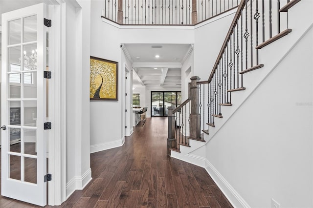 foyer entrance featuring a towering ceiling, dark wood-type flooring, and french doors