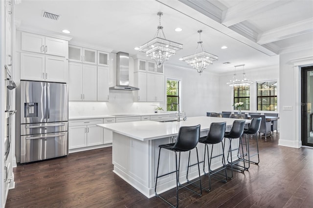 kitchen featuring a kitchen island with sink, white cabinetry, wall chimney exhaust hood, and stainless steel refrigerator with ice dispenser