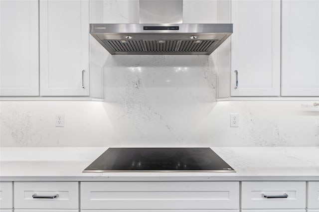 kitchen featuring tasteful backsplash, white cabinetry, exhaust hood, and black electric cooktop