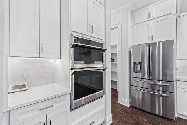 kitchen featuring white cabinetry, decorative backsplash, dark hardwood / wood-style flooring, and stainless steel appliances