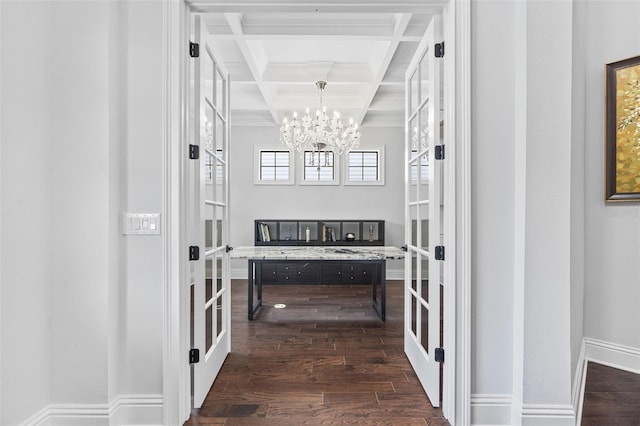 hallway with dark hardwood / wood-style floors, beamed ceiling, a chandelier, ornamental molding, and coffered ceiling