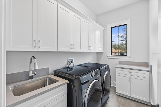 washroom featuring independent washer and dryer, cabinets, sink, and light tile patterned floors