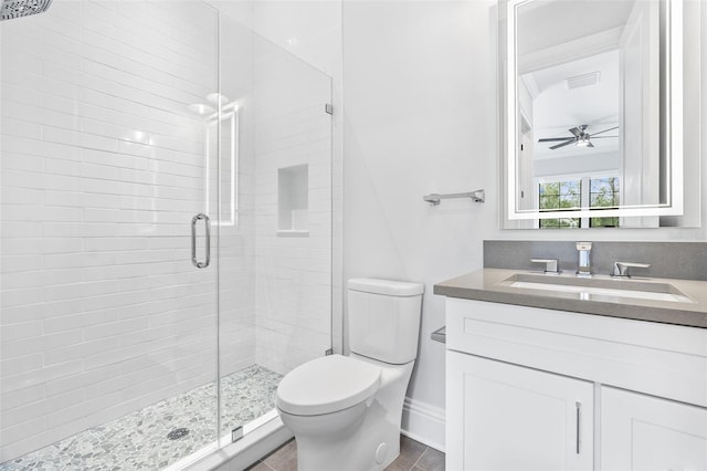 bathroom with ceiling fan, vanity, toilet, and an enclosed shower