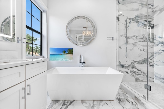 bathroom with a chandelier, vanity, and separate shower and tub