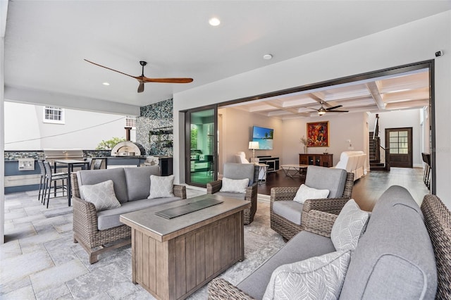 living room featuring beam ceiling, coffered ceiling, and ceiling fan