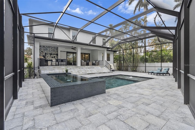 view of swimming pool featuring glass enclosure, an in ground hot tub, ceiling fan, an outdoor hangout area, and a patio