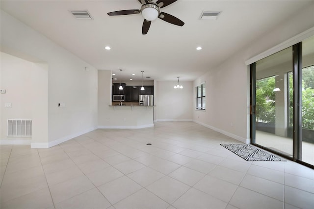 unfurnished living room featuring ceiling fan with notable chandelier and light tile patterned floors