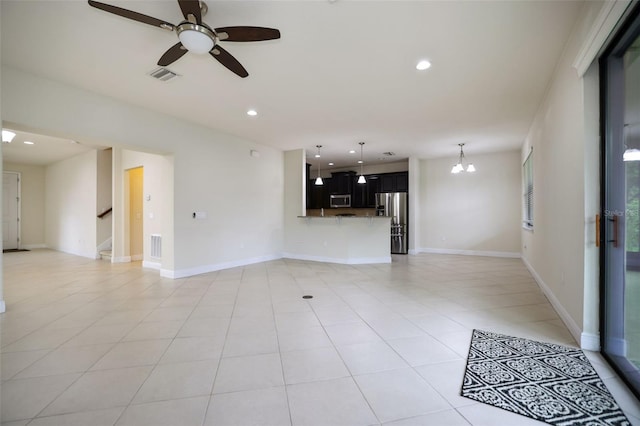 unfurnished living room featuring ceiling fan with notable chandelier and light tile patterned floors