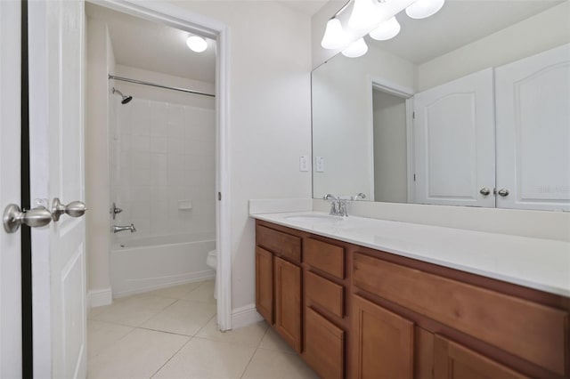 full bathroom with tile patterned flooring, vanity, tiled shower / bath, and toilet