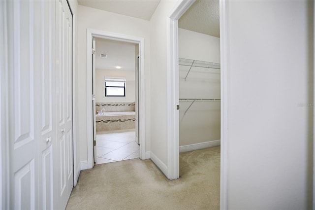 hallway featuring light colored carpet