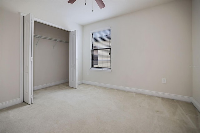 unfurnished bedroom with light carpet, ceiling fan, and a closet