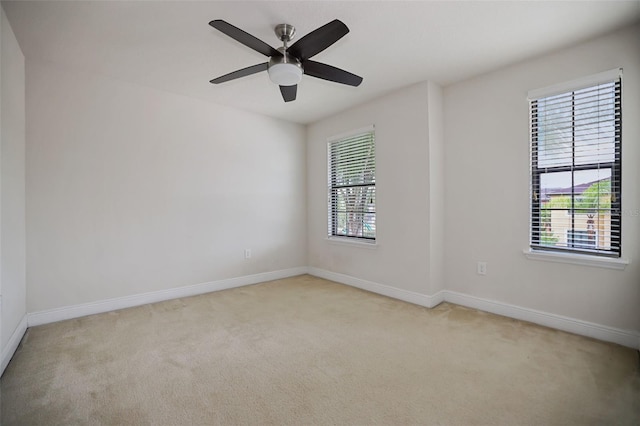 unfurnished room featuring a wealth of natural light, light colored carpet, and ceiling fan