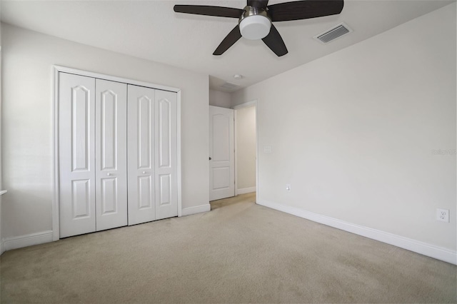 unfurnished bedroom featuring light carpet, ceiling fan, and a closet