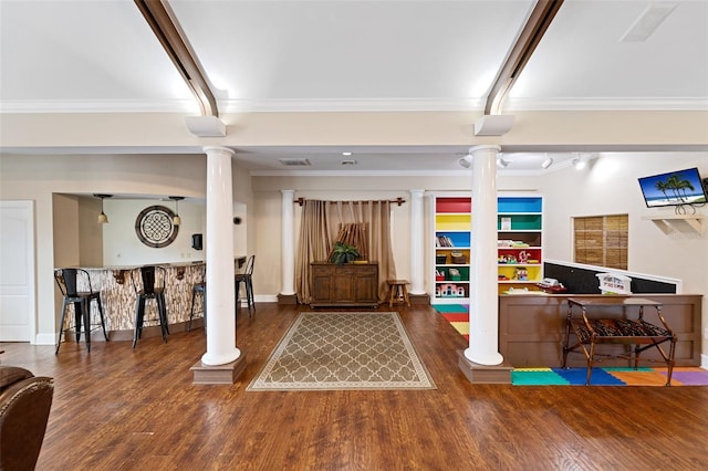 interior space with ornate columns, crown molding, indoor bar, and dark hardwood / wood-style floors