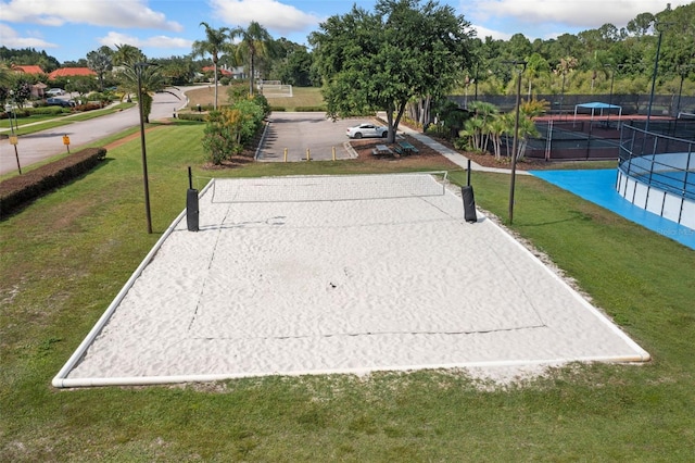 view of property's community with a lawn and volleyball court