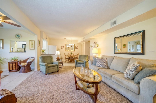 living room with ceiling fan with notable chandelier and light tile patterned flooring