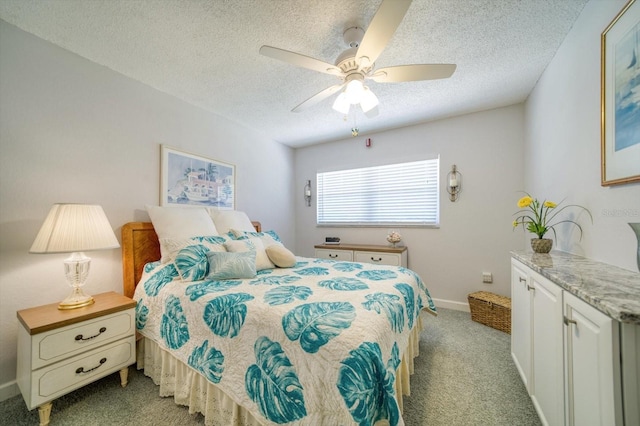 bedroom with ceiling fan, light colored carpet, and a textured ceiling