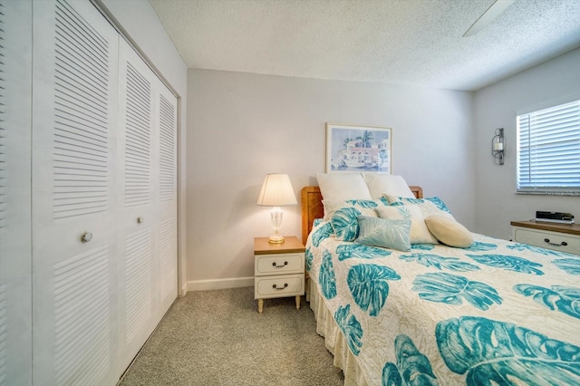 bedroom with a closet, light carpet, and a textured ceiling