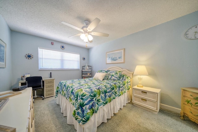 bedroom featuring ceiling fan, light colored carpet, and a textured ceiling