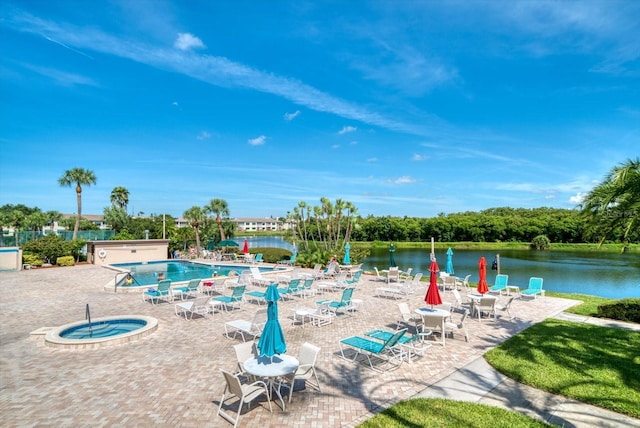 view of swimming pool with a community hot tub, a water view, and a patio area