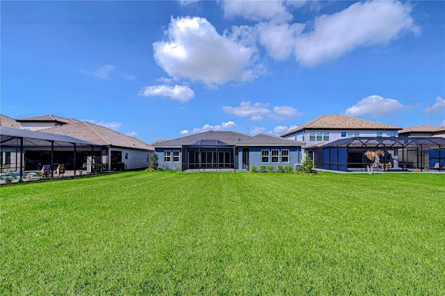 back of house with a yard and a lanai