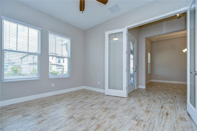 unfurnished room featuring ceiling fan, light wood-type flooring, and french doors