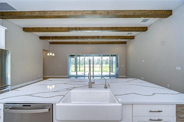 kitchen with decorative light fixtures, sink, white cabinets, light stone counters, and stainless steel appliances