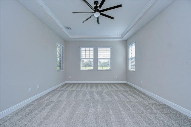 spare room with crown molding, light colored carpet, ceiling fan, and a tray ceiling