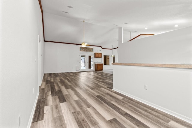 unfurnished living room featuring hardwood / wood-style floors, high vaulted ceiling, french doors, and ceiling fan